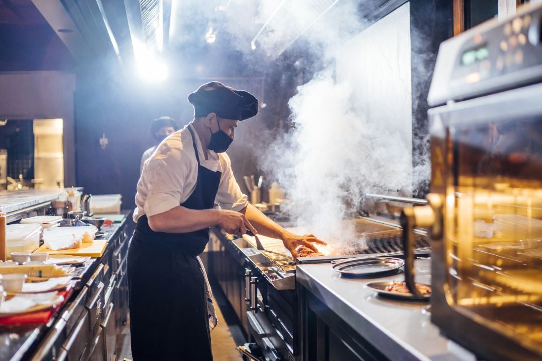 Chef preparando una comida en la cocina de un restaurante.