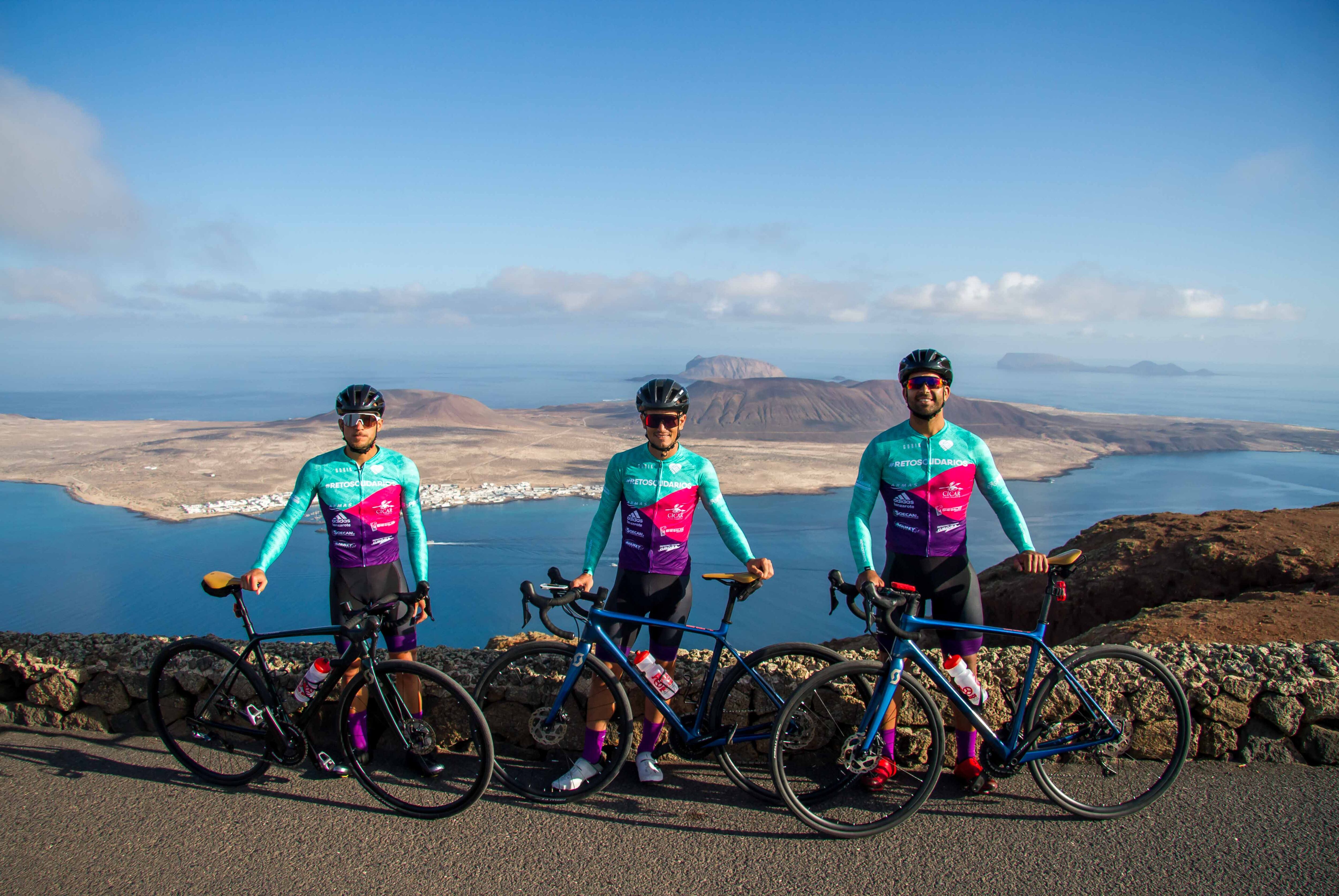 Rubén Toribio, Ayose Tejera y Toño Cedrés con la isla de La Graciosa al fondo.