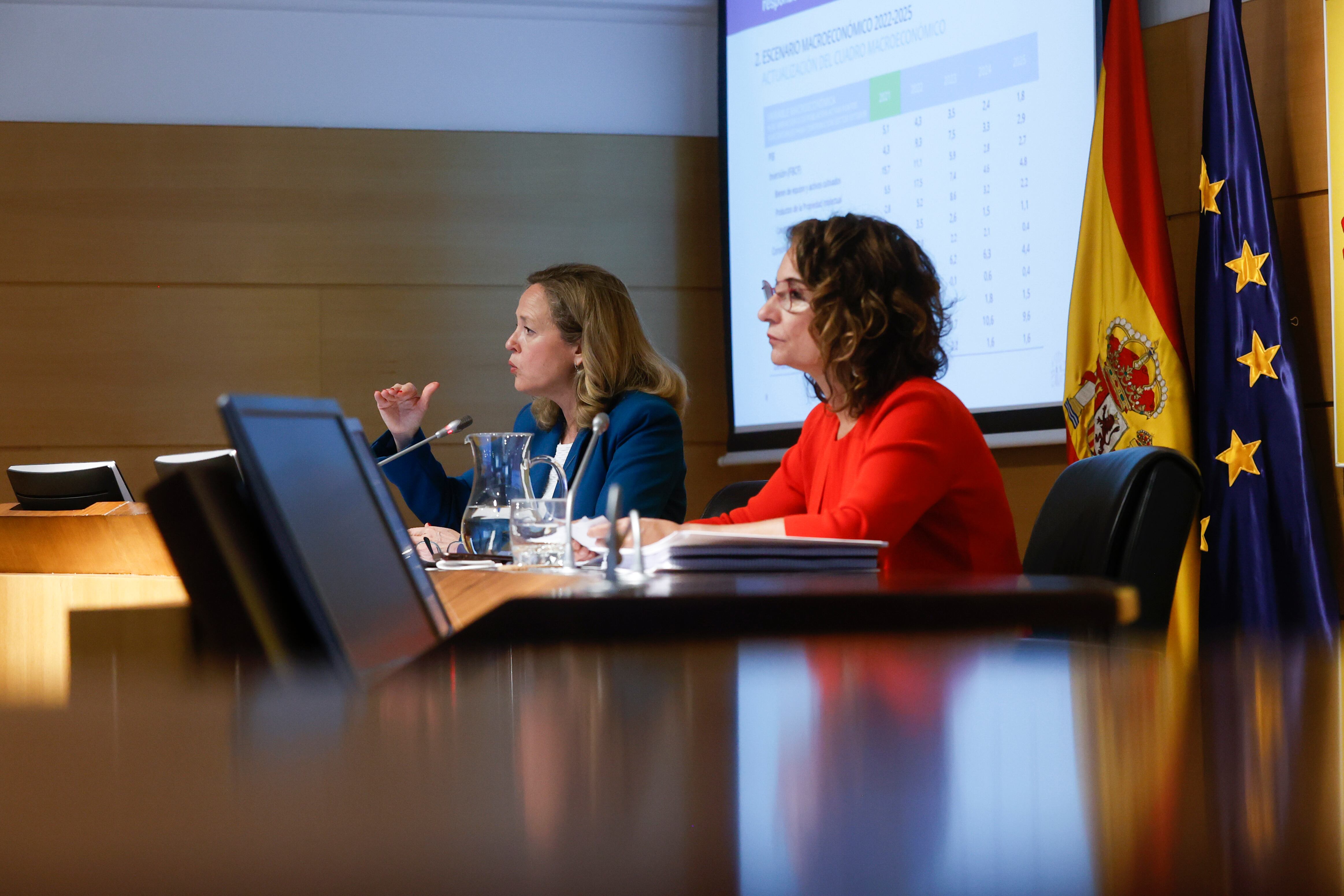 La ministra de Hacienda y Función Pública, María Jesús Montero (d), y la vicepresidenta primera y ministra de Asuntos Económicos, Nadia Calviño, durante la presentación del escenario macroeconómico 2022-2025, este viernes en el Ministerio de Economía en Madrid.