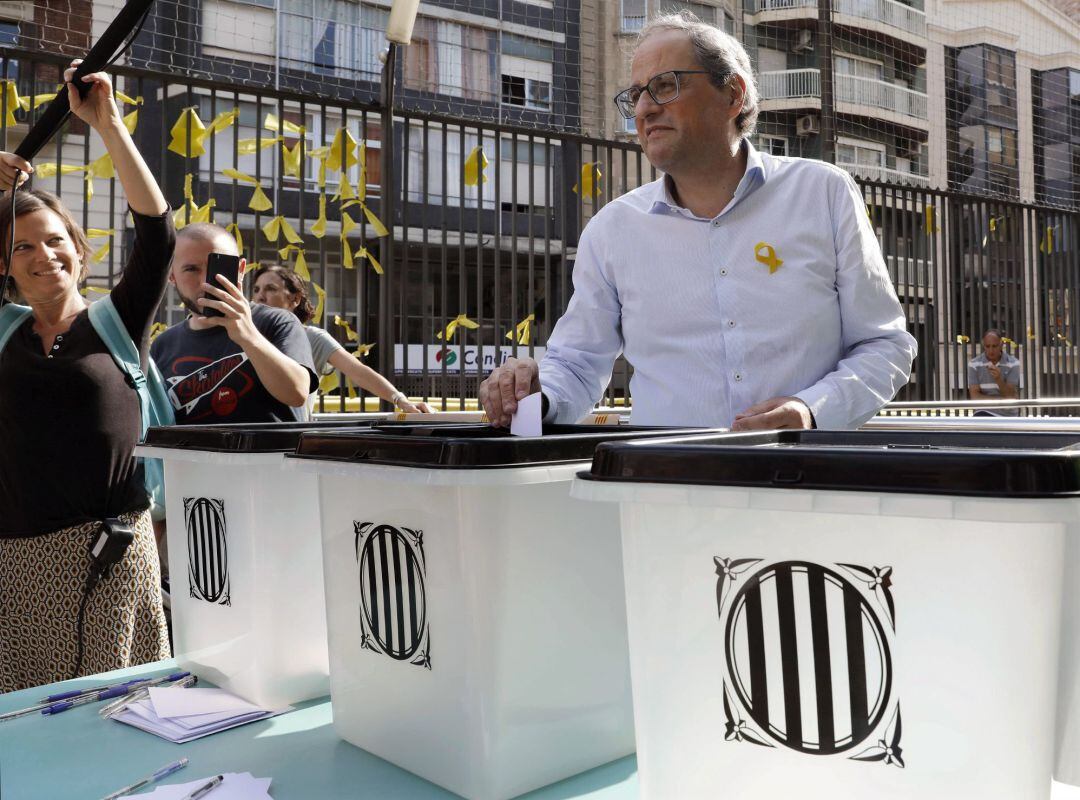 El presidente de la Generalitat, Quim Torra, deposita un deseo escrito en una papeleta en una de las urnas utilizadas el 1-O