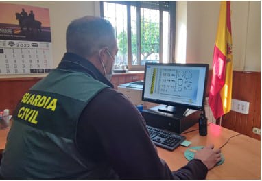 Un guardia civil consulta un ordenador en el que se observan joyas recuperadas de un robo.