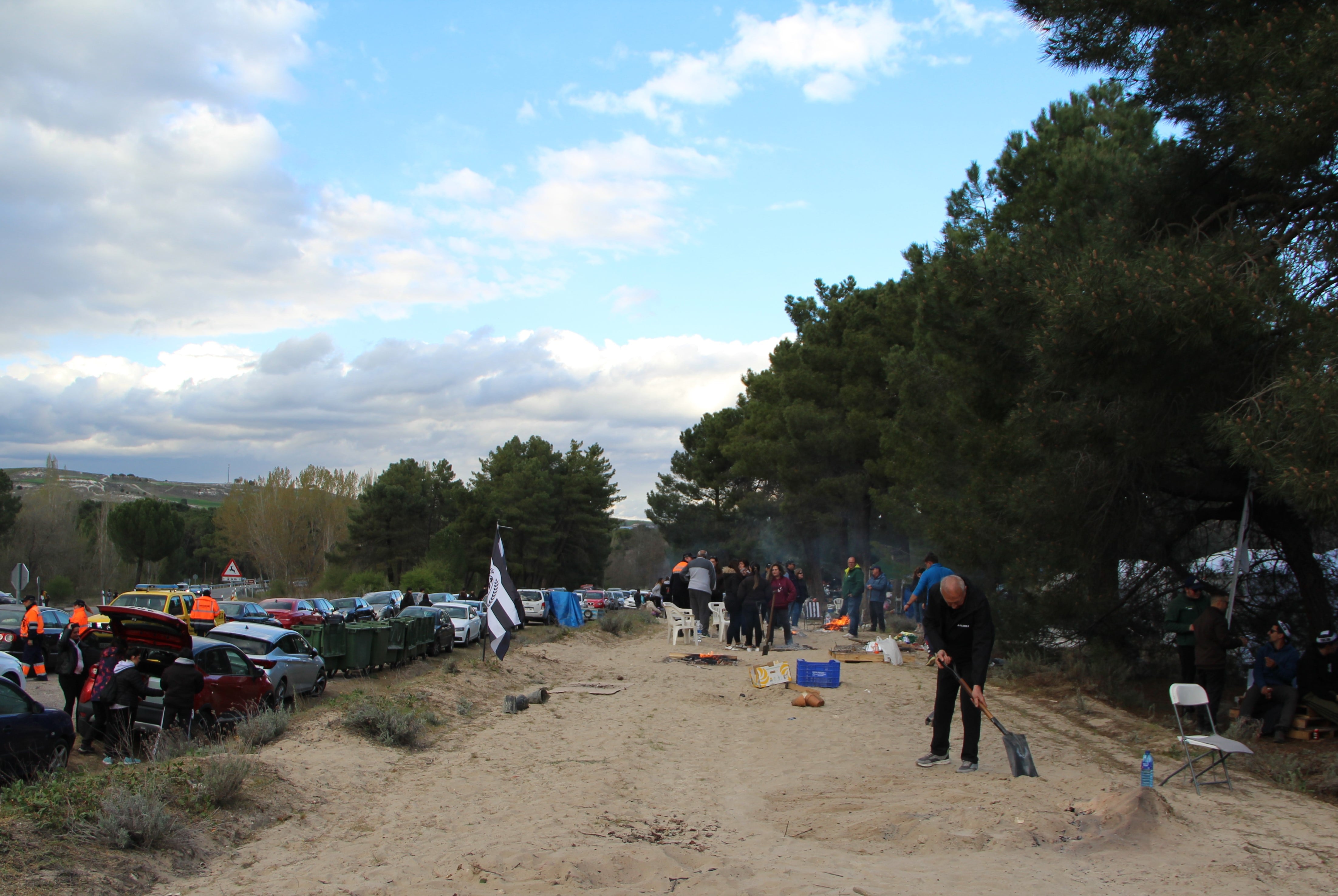 Un hombre tapa una hoguera en el cortafuegos donde se permitieron las hogueras el 'Día de las Chuletas' en Cuéllar