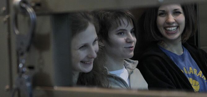 Las integrantes del grupo de punk ruso Pussy Riot Maria Alyokhina (izq), Yekaterina Samutsevich (c) and Nadezhda Tolokonnikova (der), sentadas en el interior de la zona acristalada del Tribunal Municipal de Moscú