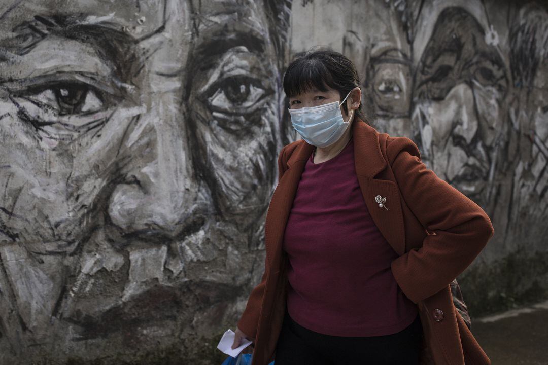 Una habitante de Wuhan camina con mascarilla.