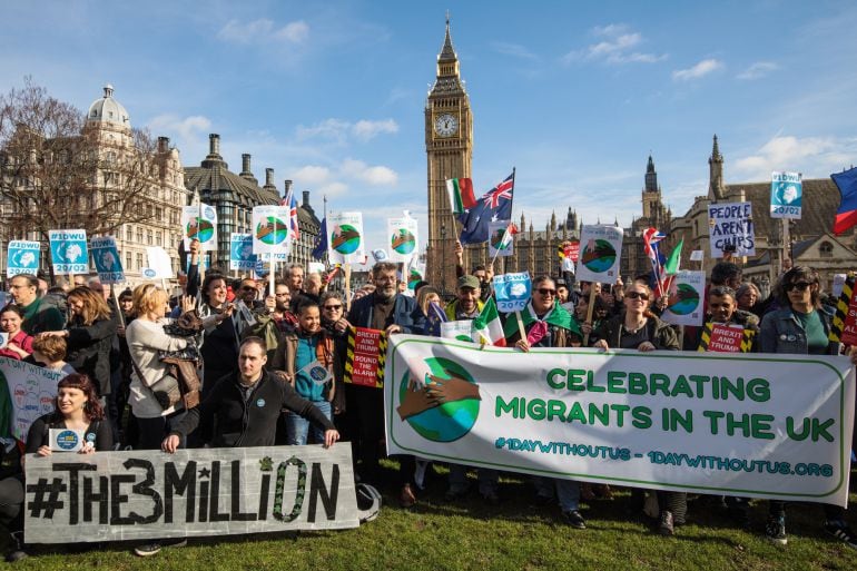 Protesters and migrant workers hold banners and flags as they demonstrate outside Parliament on February 20, 2017 in London