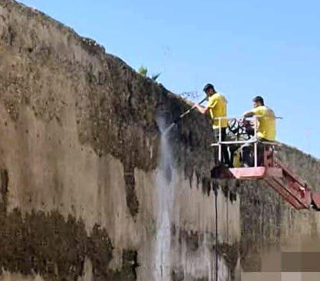 Operarios limpiando la muralla de Palma del Río