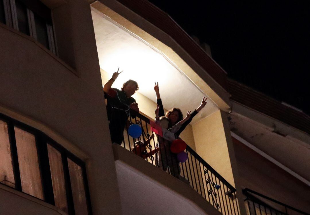 Dos donostiarras saludan desde su balcón durante la cuarentena. 