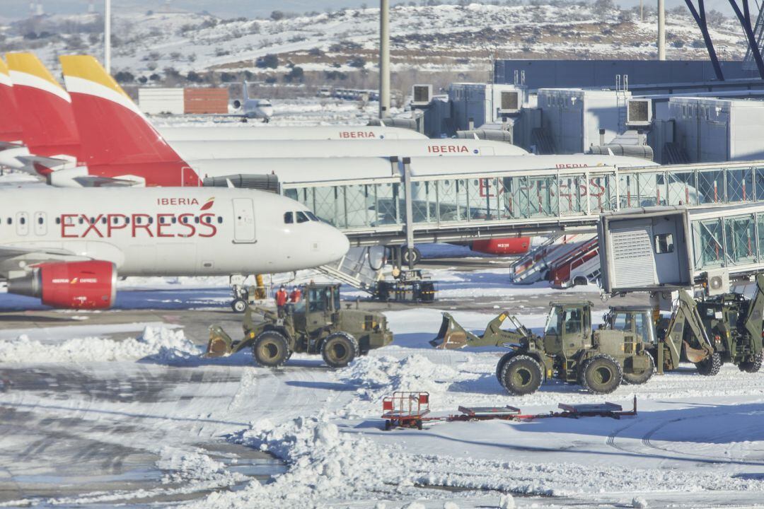 Varias excavadoras de la Unidad Militar de Emergencias (UME) trabajan para quitar la nieve y el hielo de la pista del aeropuerto Madrid-Barajas Adolfo Suárez