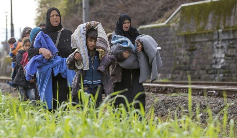 Refugiados caminan por las vías del tren en la frontera entre Austria y Eslovenia en Spielfeld (Austria).