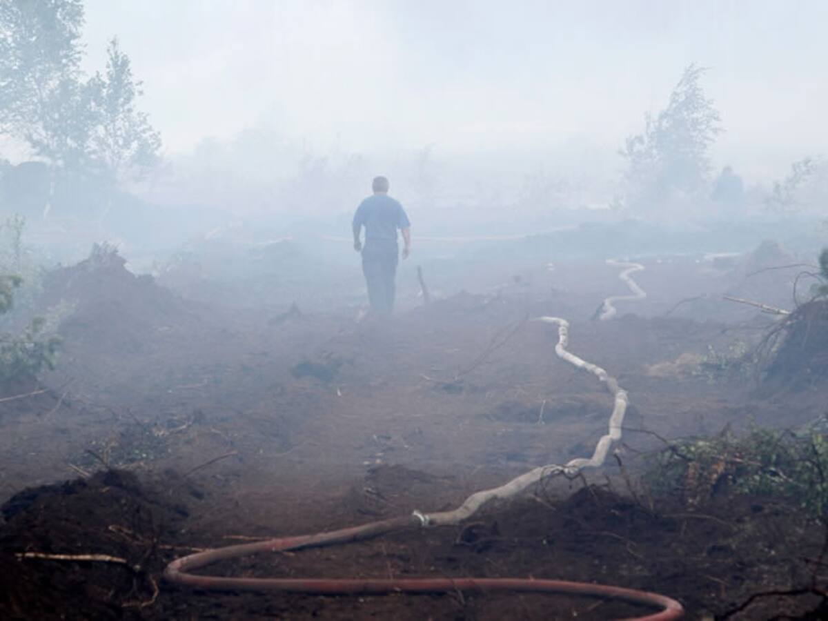 Un bombero camina entre el humo en un bosque devastado por las llamas en Shatura, Rusia