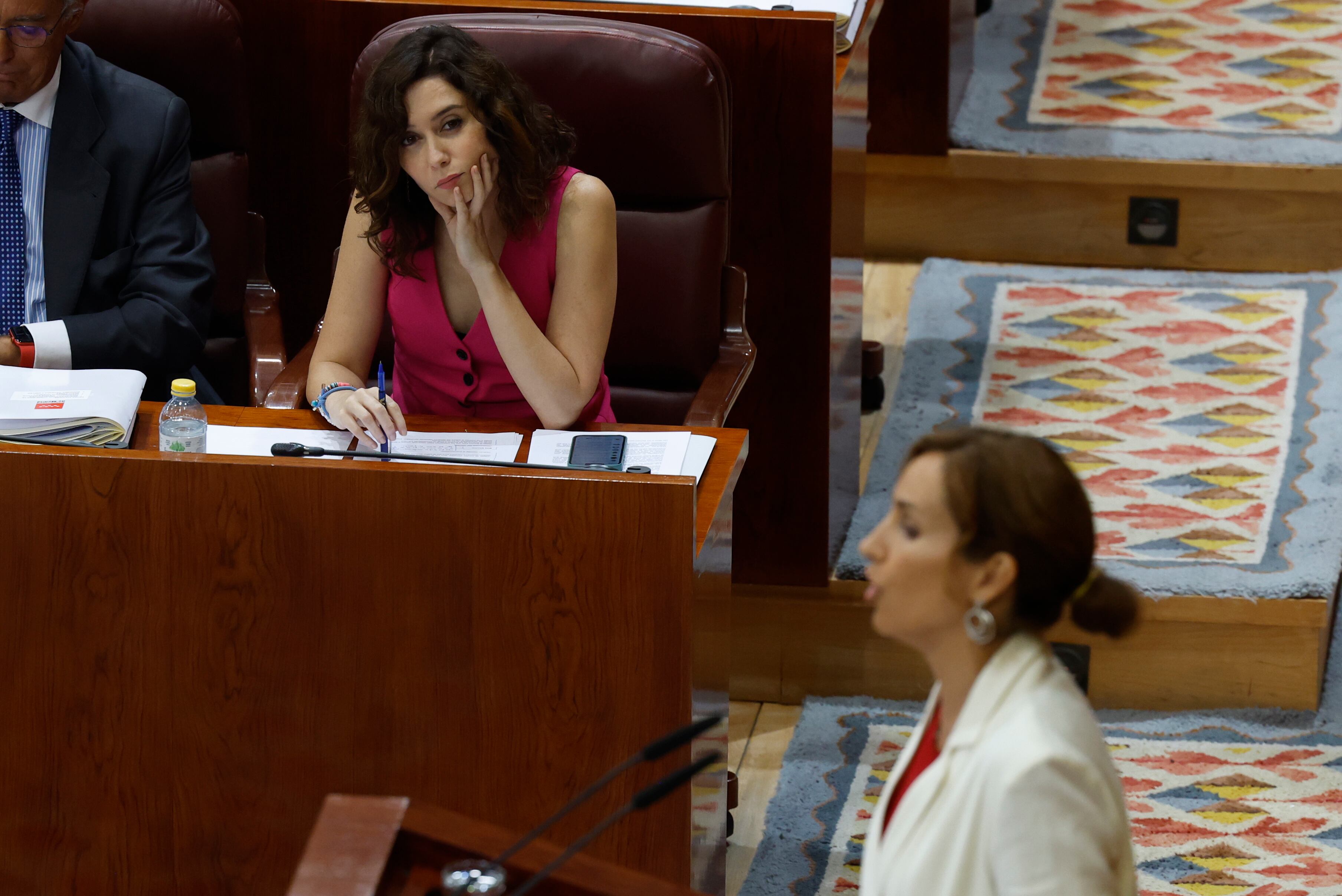 La presidenta de la Comunidad de Madrid, Isabel Díaz Ayuso (i), escucha la intervención de la portavoz de Más Madrid, Mónica García, este martes, durante la egunda sesión del debate del estado de la región en la Asamblea de Madrid.