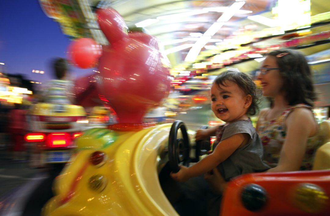 Fotografía de archivo de unas niñas disfrutando de las atracciones infantiles 