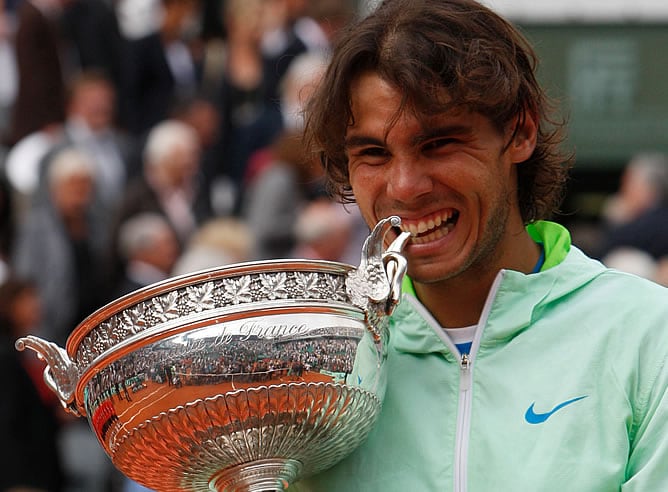 Rafa Nadal celebra su triunfo en Roland Garros mordiendo la Copa de los Mosqueteros