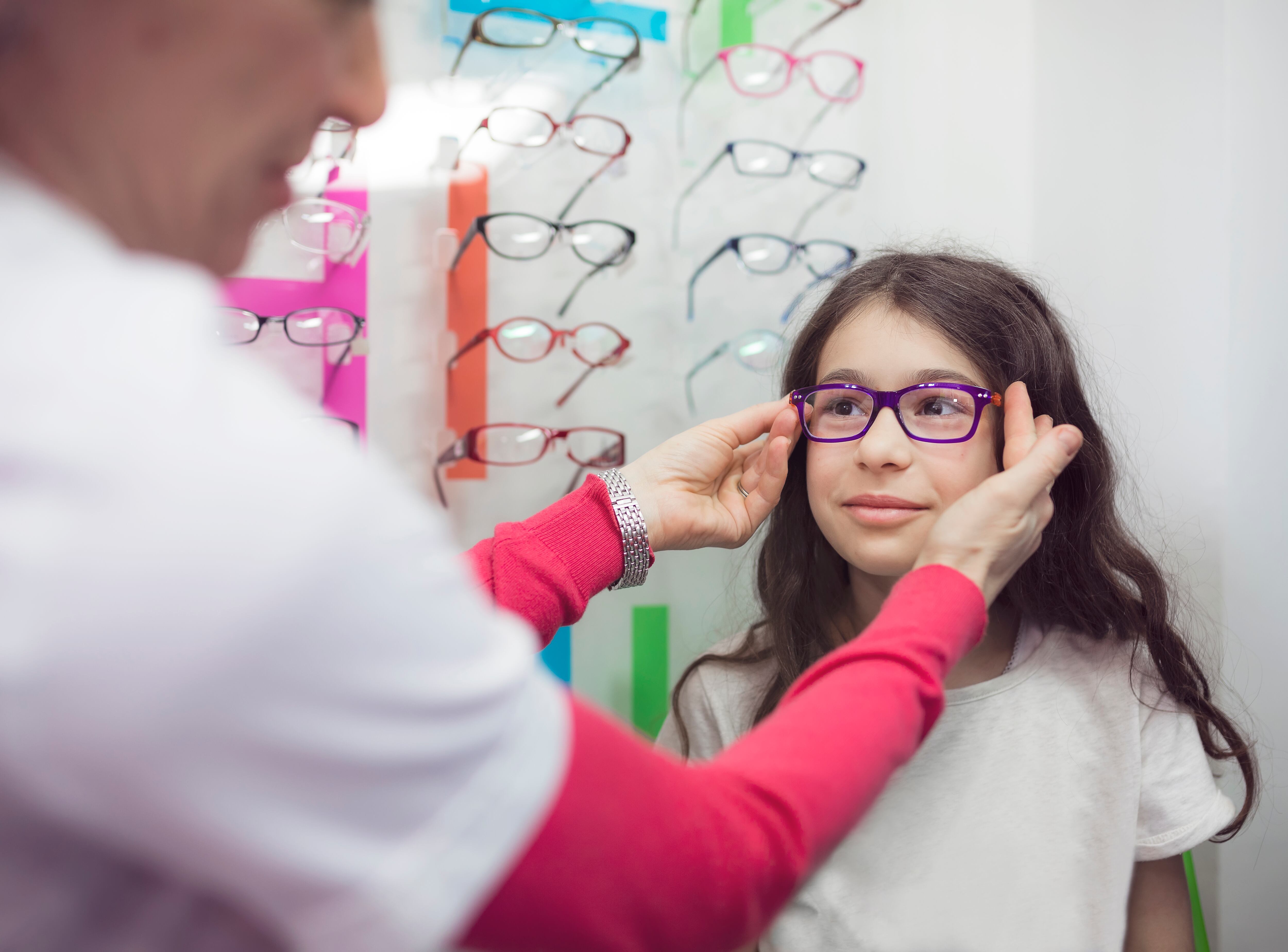 Little girl trying on optic glasses in 