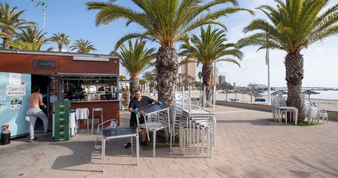 Los propietarios de un chiringuito en la playa de Barnuevo, en San Javier, preparaban la terraza para abrir el lunes