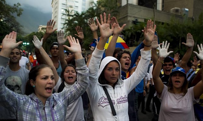 Un grupo de personas gritas consignas durante una protesta contra el Gobierno de Venezuela