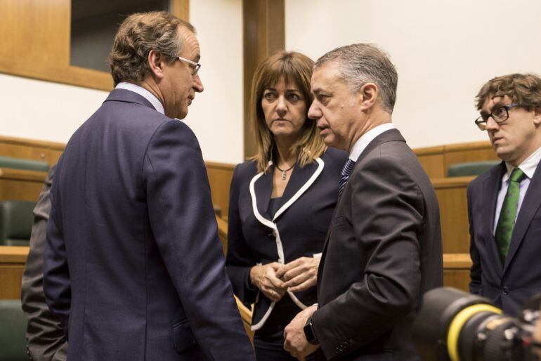 El lehendakari en funciones, Iñigo Urkullu (2d), conversa en el Parlamento Vasco con el presidente del PP regional, Alfonso Alonso (i), y la secretaria general del PSOE-EE, Idoia Mendia, momentos antes de exponer hoy su proyecto en el pleno de investidura