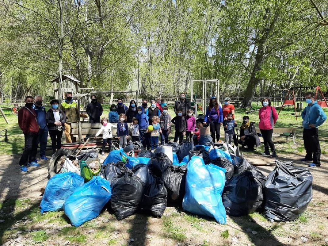 Padres y niños posan con la basura recolectada