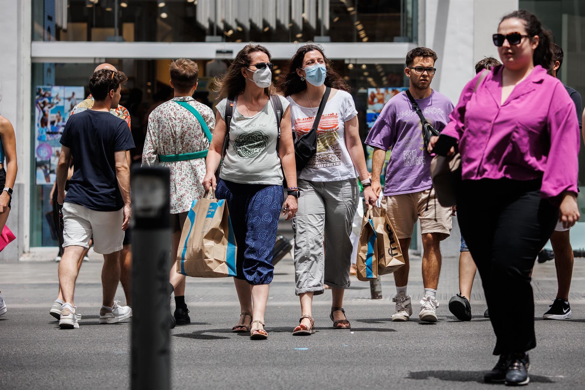 Gente con mascarilla caminando por la calle