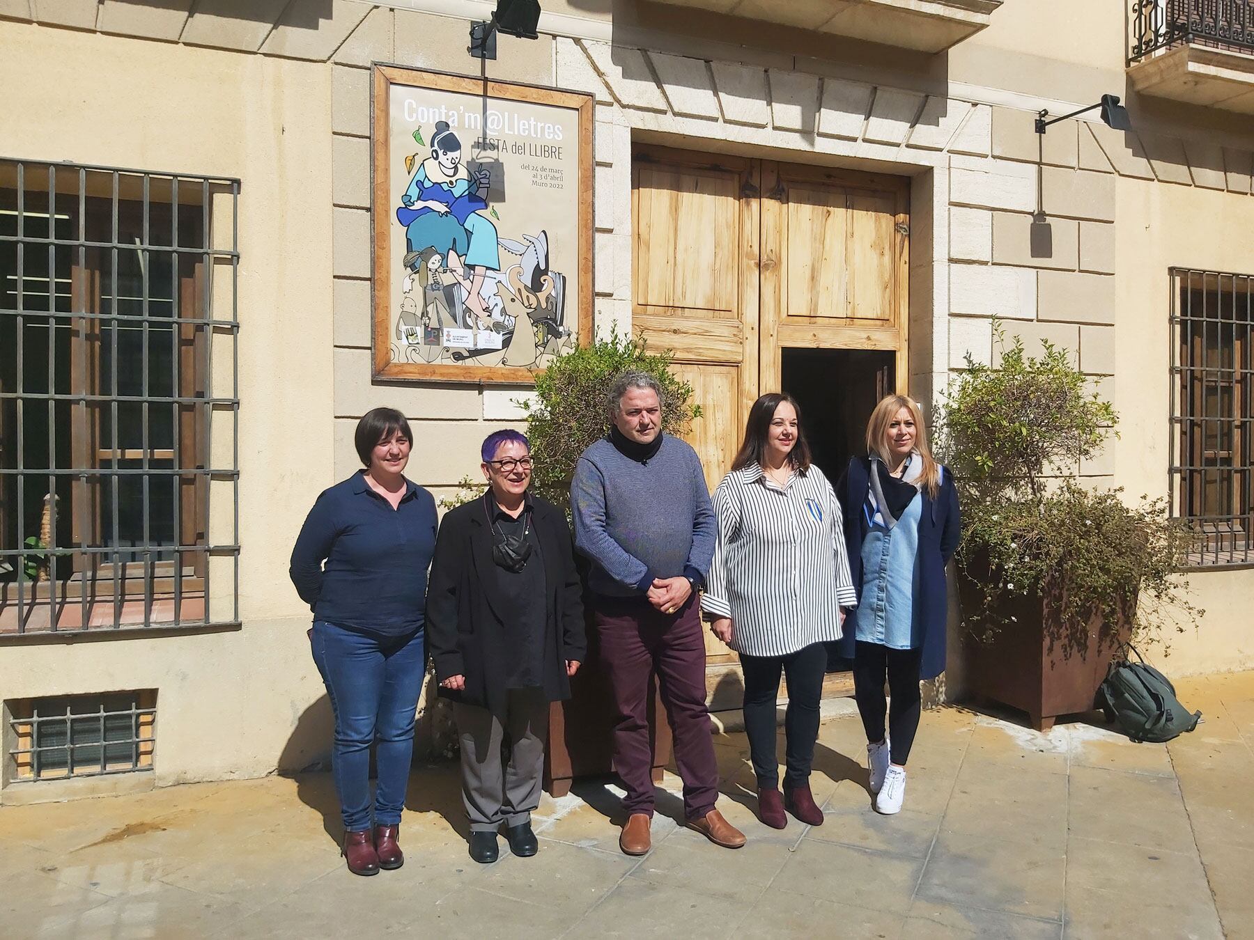 Instants després del descobriment del cartell de la Festa del Llibre de Muro en la façana de l'Ajuntament