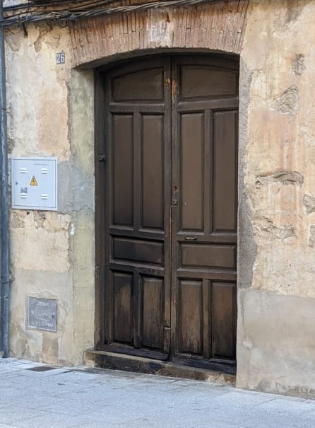 La puerta de madera ha quedado dañada por el fuego antes de apagarse sin lograr a penetrar dentro de la vivienda