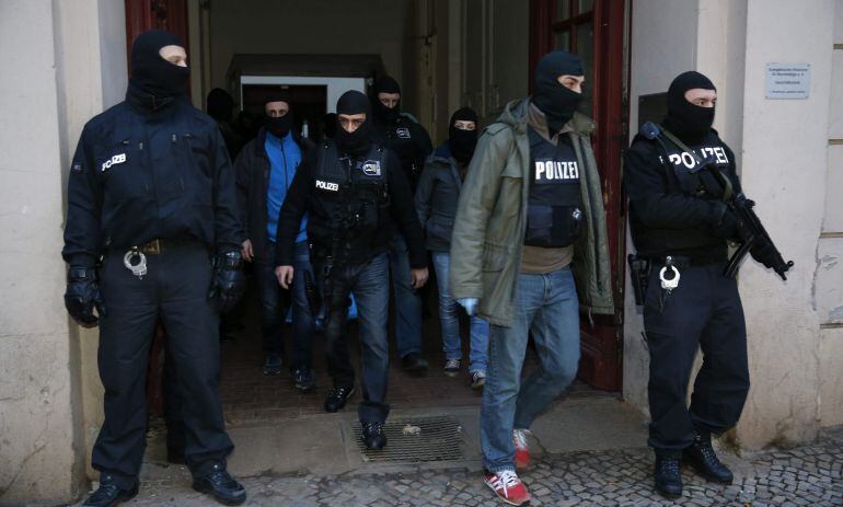 Agentes de la Policía alemana salen de un edificio de apartamentos en el barrio de Wedding, después de arrestar a dos turcos