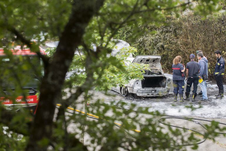 Efectivos policiales junto al vehículo quemado en el que se ha encontrado el cadáver