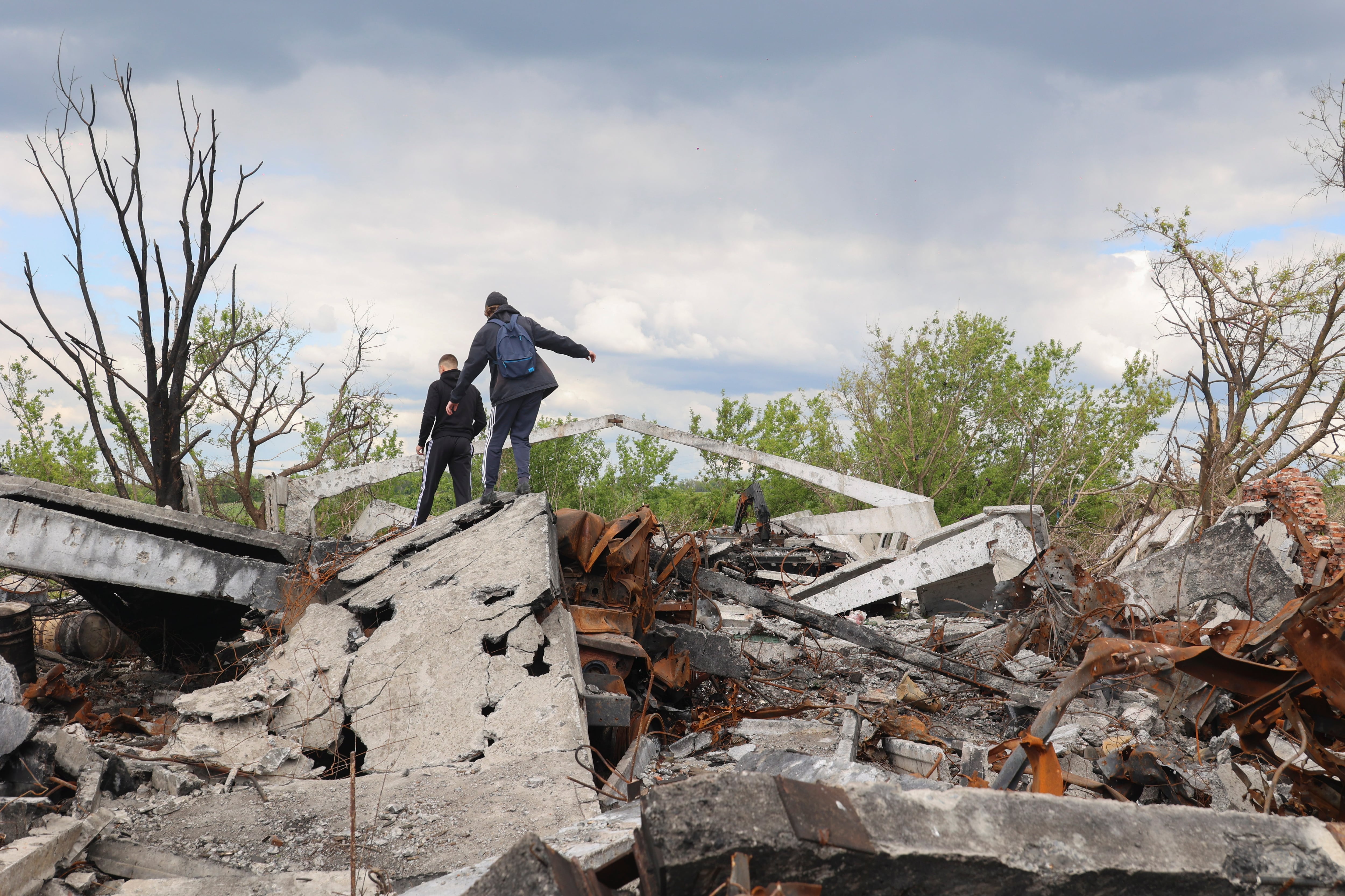 Kharkiv (Ukraine), 18/05/2022.- Ukrainian teenagers walk on the debris of a shelled building in Mala Rohan&#039; village near Kharkiv, Ukraine, 18 May 2022. Russian troops were recently pushed out from Kharkiv&#039;s outskirts by the Ukrainian army. Ukraine&#039;s second-largest city Kharkiv and its surroundings witnessed repeated airstrikes from Russian forces. On 24 February, Russian troops invaded Ukrainian territory starting a conflict that has provoked destruction and a humanitarian crisis. According to the UNHCR, more than 6.3 million refugees have fled Ukraine, and a further 7.7 million people have been displaced internally within Ukraine since. (Rusia, Ucrania) EFE/EPA/SERGEY KOZLOV
