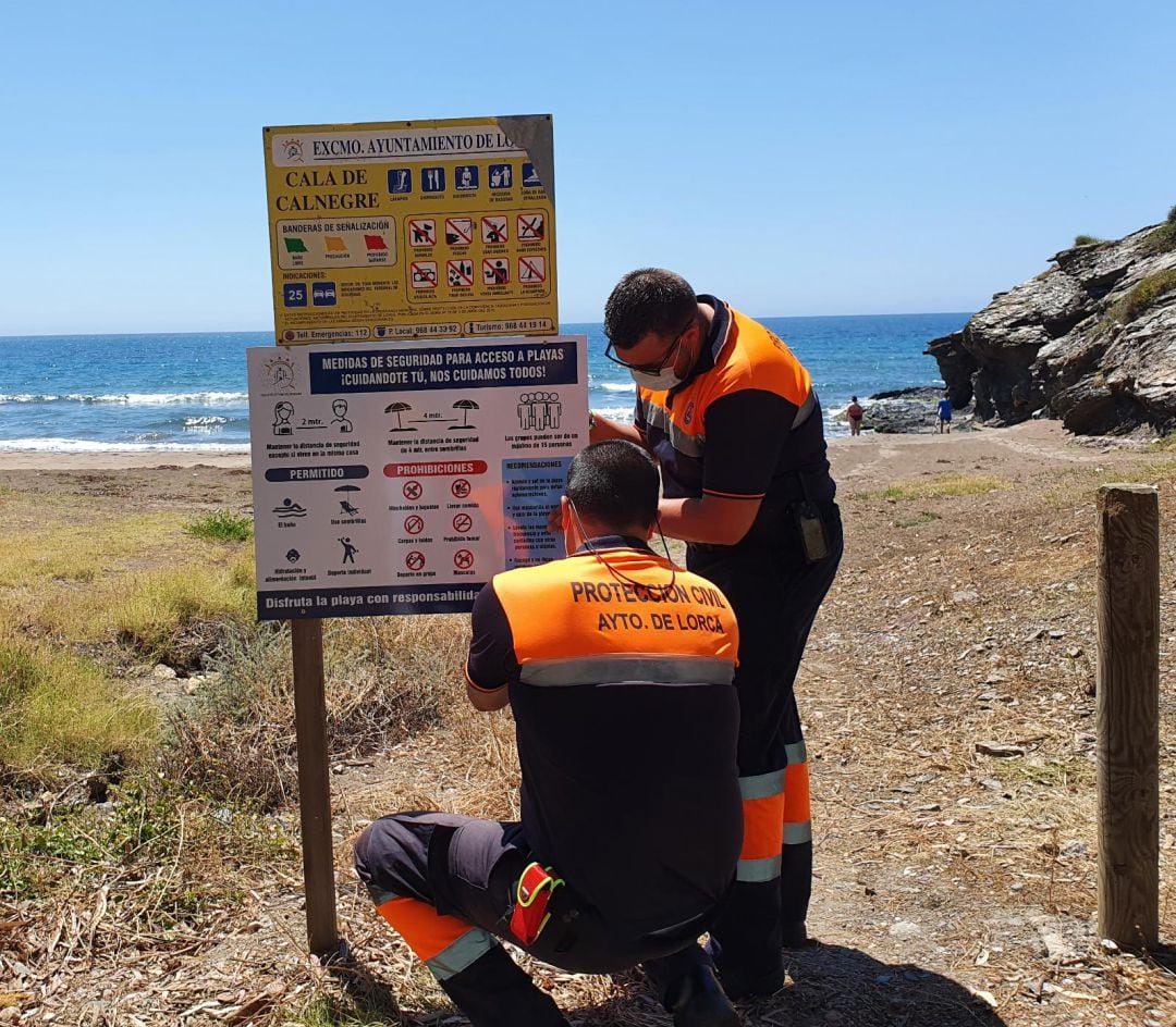 Voluntarios de Protección Civil instalan los carteles informativos