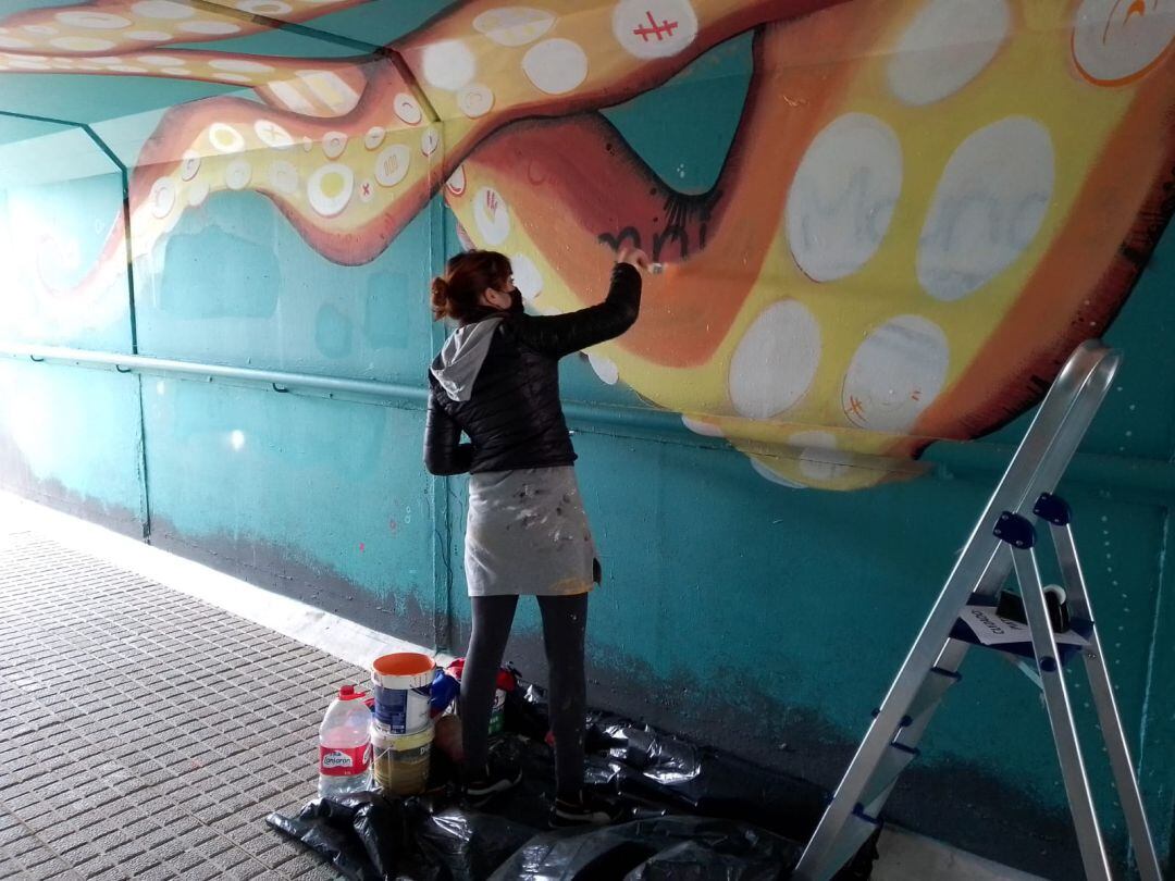 Marina Casao restaura uno de los grafiti en Bezana.