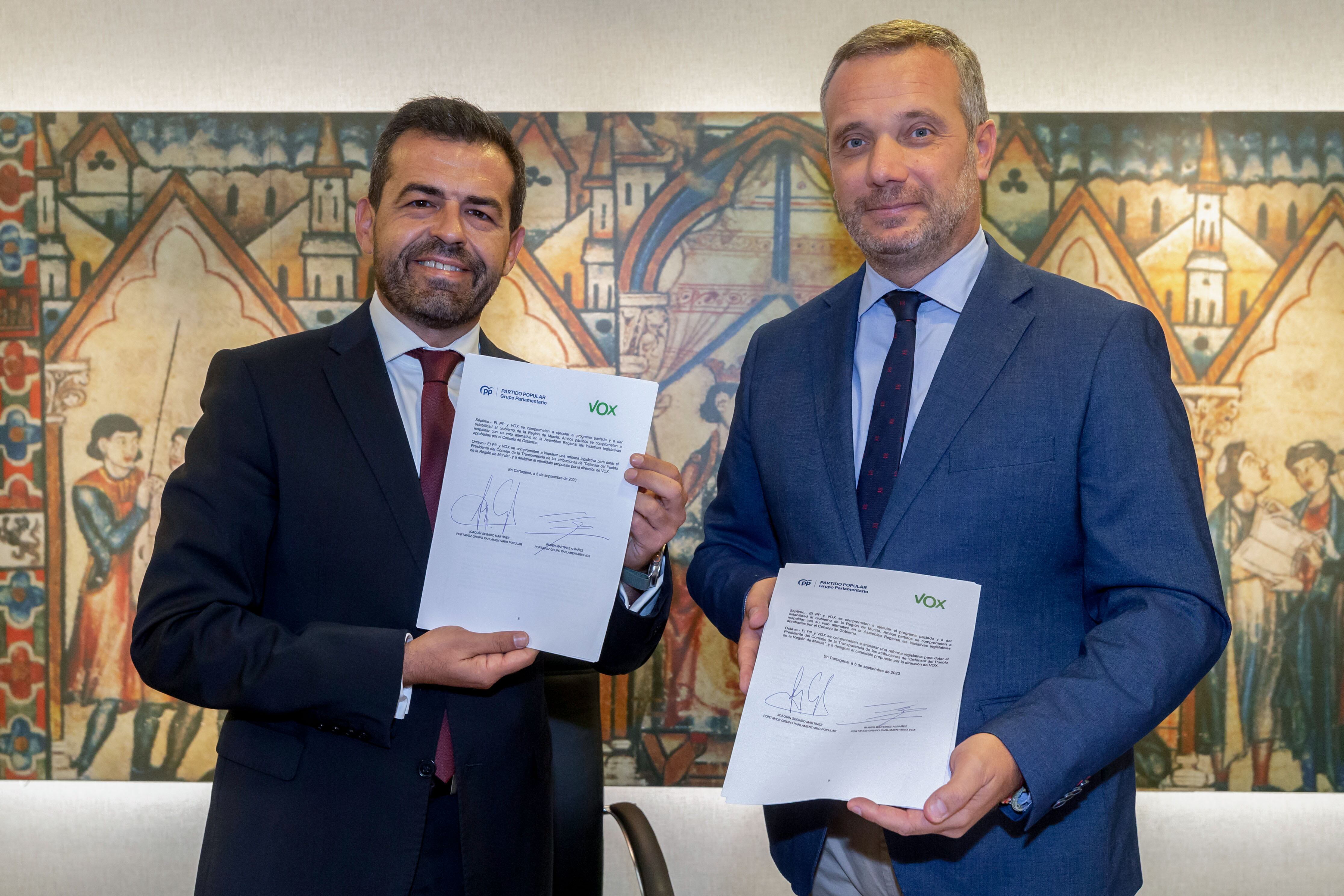 Archivo - Los portavoces de Vox Rubén Martínez (i) y del PP Joaquín Segado (d) en el parlamento murciano se dan la mano tras la firma del acuerdo de gobierno este martes en la Asamblea Regional en Cartagena en 2023