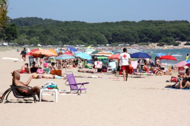 Banyistes a la platja Llarga de Tarragona, i un socorrista de la Creu Roja al mig, a finals d&#039;aquest juliol