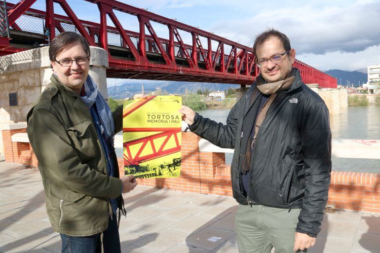 El president d&#039;Amics i Amigues de l&#039;Ebre, Marc March, i el responsable de l&#039;empresa Terra Enllà, Andreu Caralt, davant del Pont Roig de Tortosa on tindrà lloc l&#039;acte del 15 d&#039;abril.