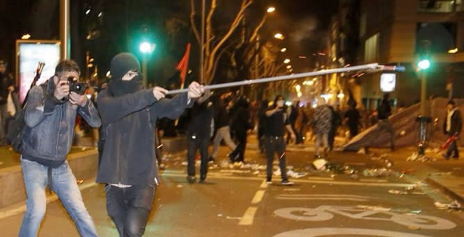 Un joven lleva una bengala en sus manos durante los incidentes posteriores a la manifestación del 22-M