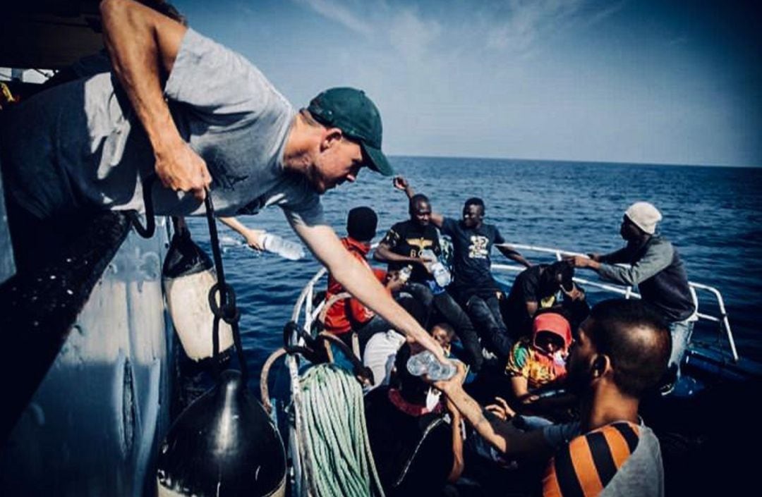 Adrián Pérez, primer oficial del barco &#039;Open Arms&#039;, ayuda a subir a bordo a los migrantes rescatados en alta mar.