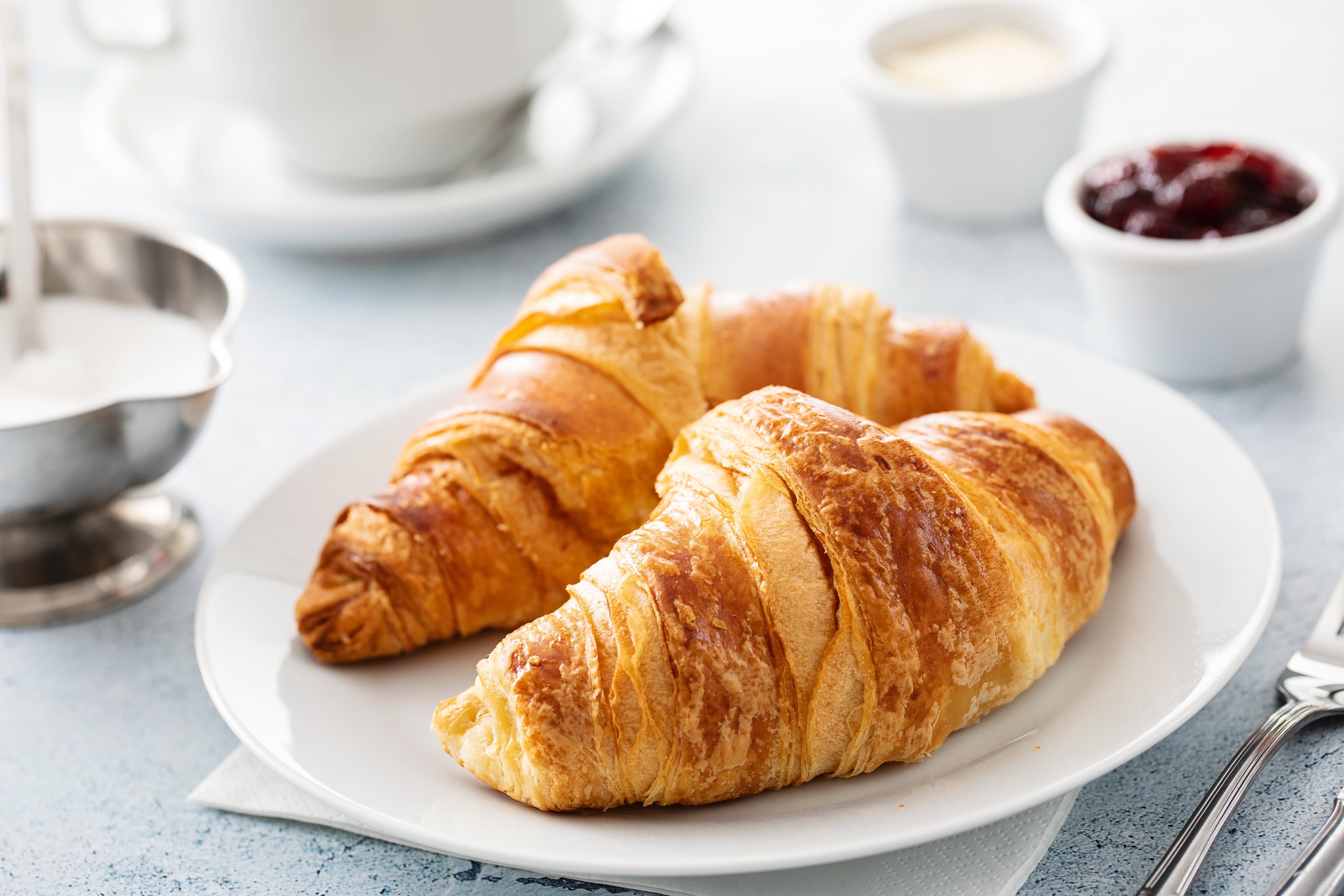 Close up of continental breakfast table with croissants and coffee cup