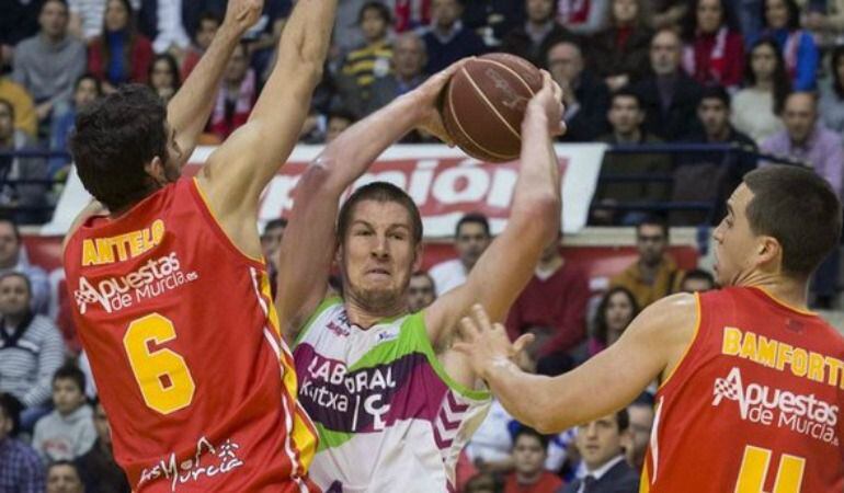 Iverson intenta una canasta ante dos jugadores de Ucam Murcia
