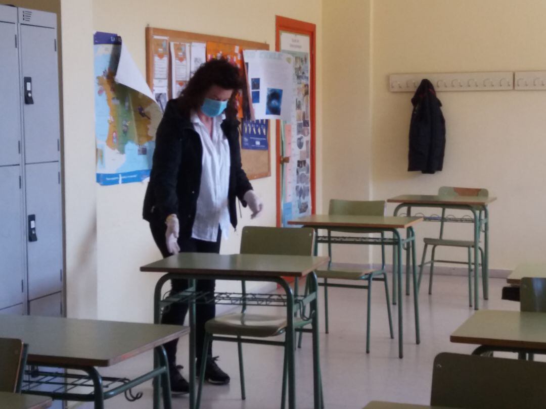 Una trabajadora desinfecta un aula
