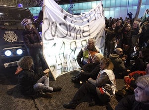 Varios manifestantes protagonizan una sentada durante la protesta organizada por la Mesa en Defensa de la Sanidad Pública contra las medidas sanitarias previstas por la Comunidad de Madrid para 2013, que ha tenido lugar esta tarde ante la Asamblea de Madr