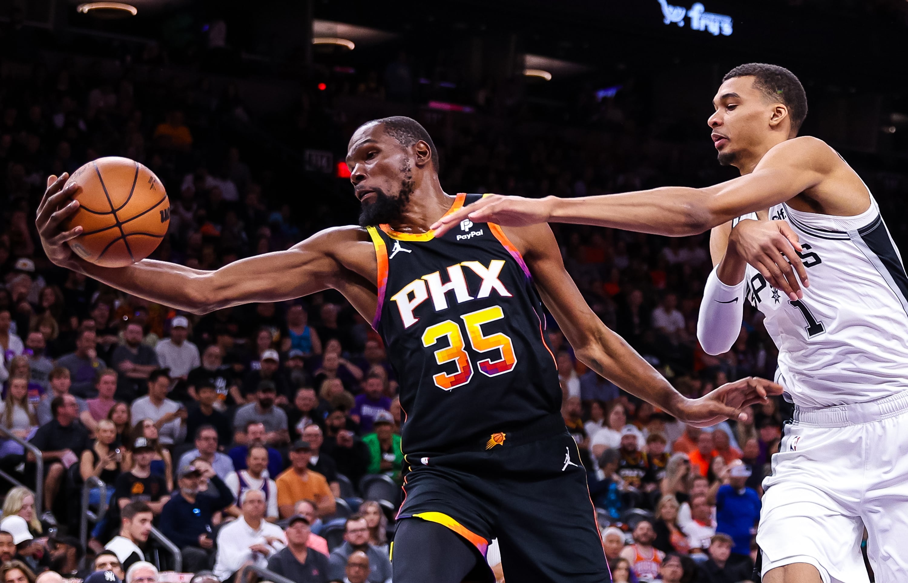 Kevin Durant intenta controlar una pelota ante la presión de Victor Wembanyama durante el Phoenix Suns-San Antonio Spurs