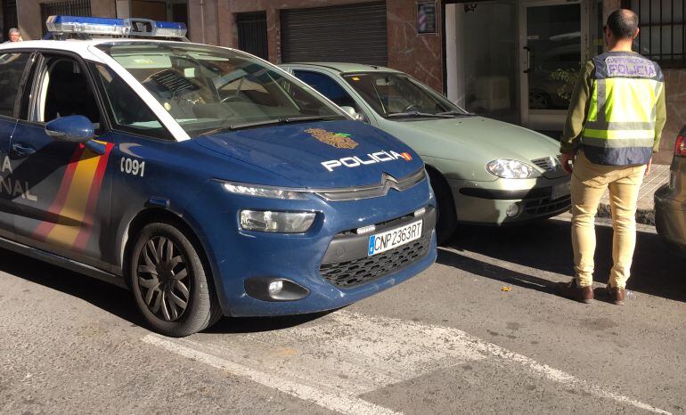 Imagen de un coche y un agente de la Policía Nacional