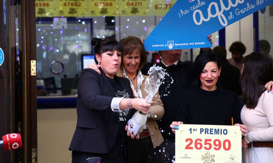 Tres mujeres celebran en la puerta de la administración de Doña Manolita, en Madrid, el premio Gordo de la Lotería de Navidad