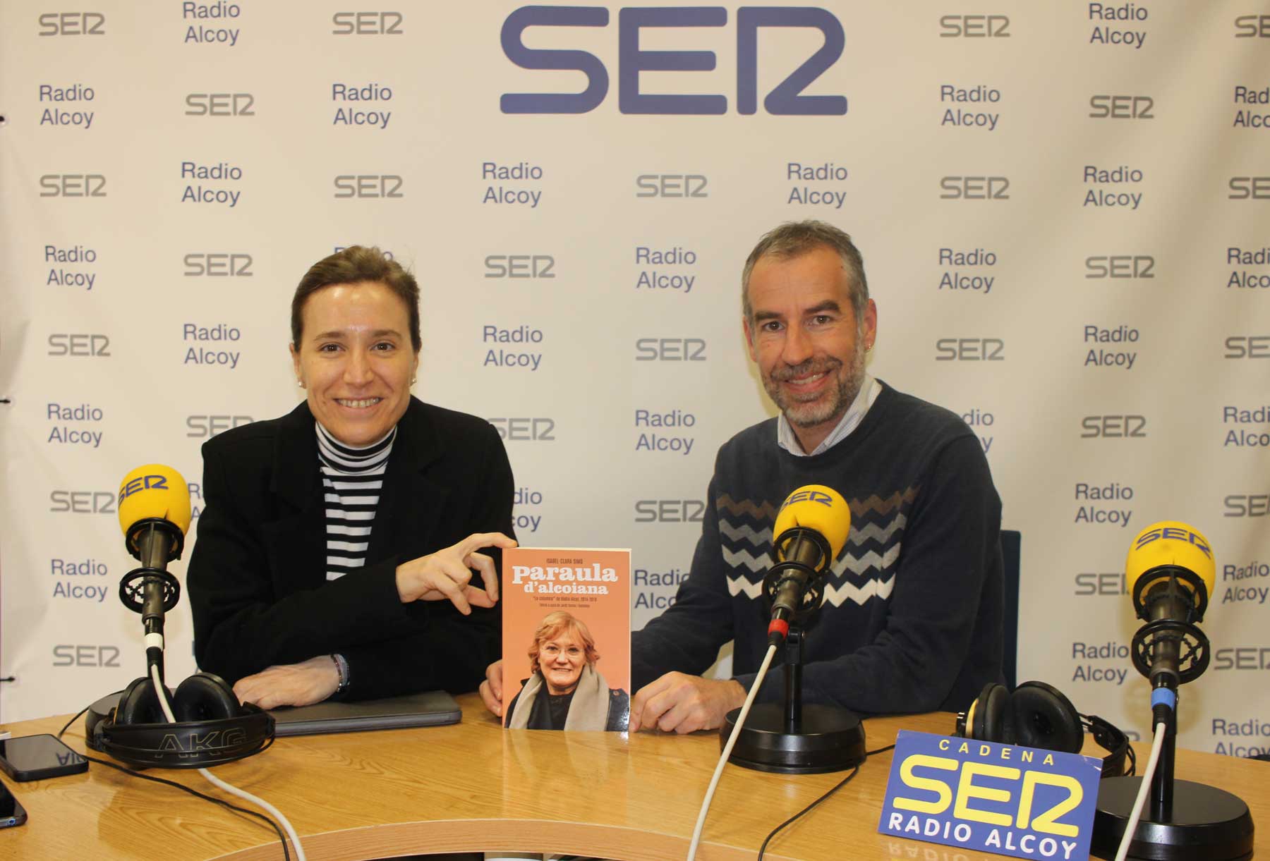 Elisa Guillem i Jordi Tormo, en l'estudi central de Ràdio Alcoi, amb un exemplar del llibre, 'Paraula d'alcoiana'