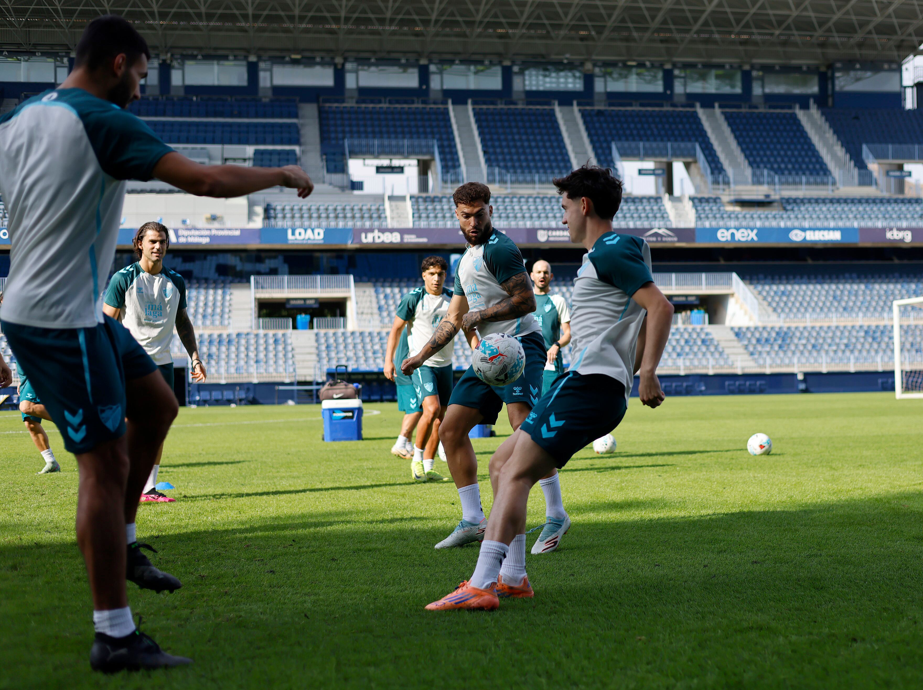 Ochoa controla el balón ante Dani Sánchez, en un entrenamiento del Málaga