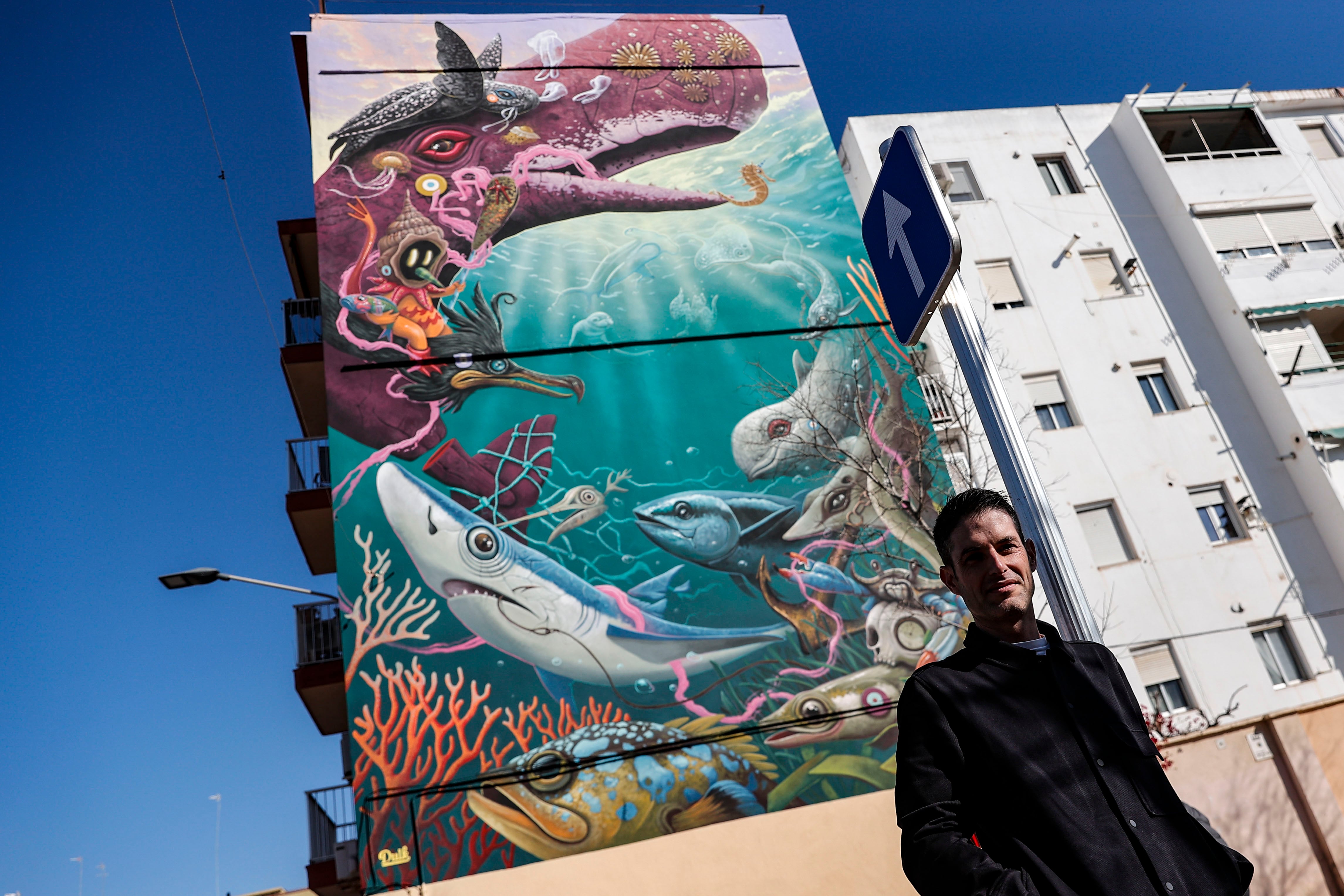 GRAFCVA5259. VALÈNCIA, 06/02/2025.- El artista valenciano Antonio Segura, conocido como Dulk, posa ante su obra &quot;Mediterraneus&quot;, un mural de gran formato en el barrio del Cabanyal sobre especies amenazadas, que ha realizado en colaboración con el Oceanogràfic de València. EFE/Manuel Bruque
