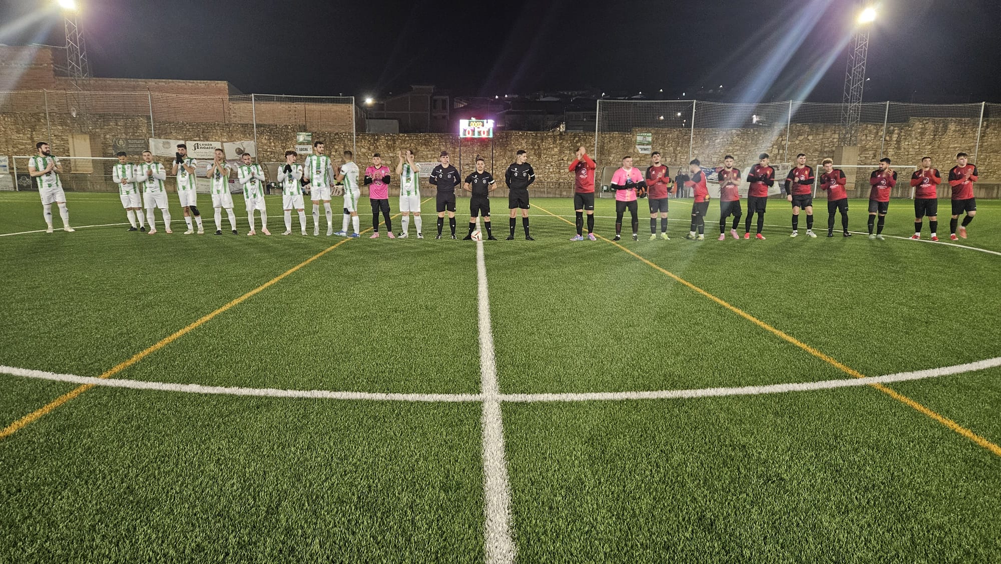 Los dos equipos y el trío arbitral en el saludo inicial