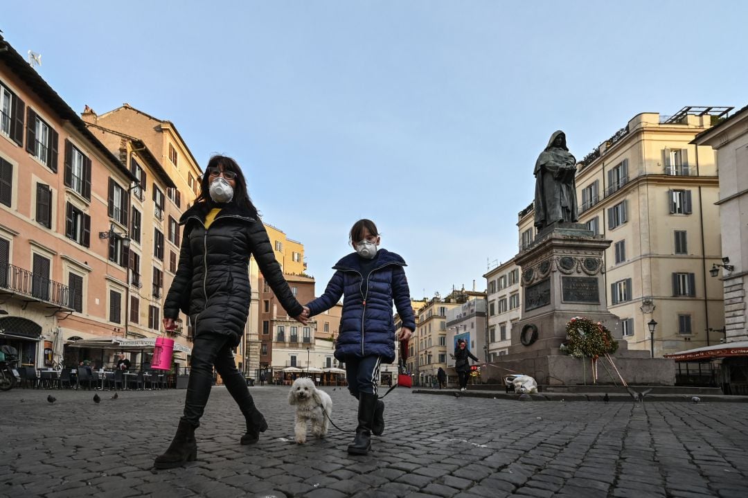 Una niña pasea con su madre por las calles de Roma