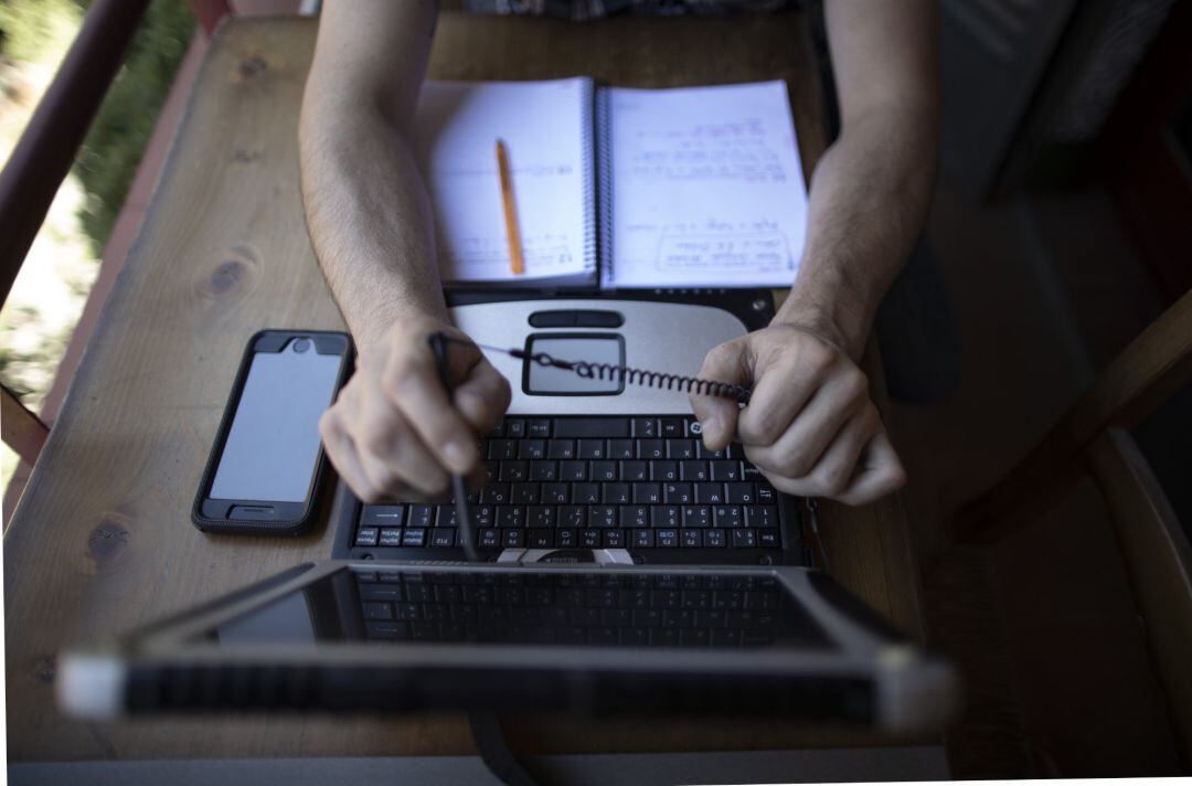 Un hombre teletrabajando desde su casa con un portátil.