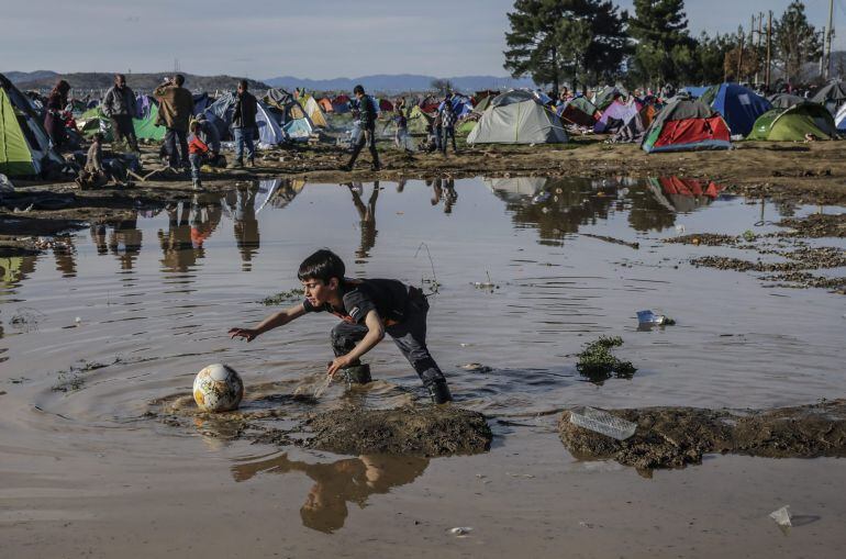 Un niño juega con un balón en el campamento de refugiados de Idomeni, en la frontera de Grecia con Macedonia