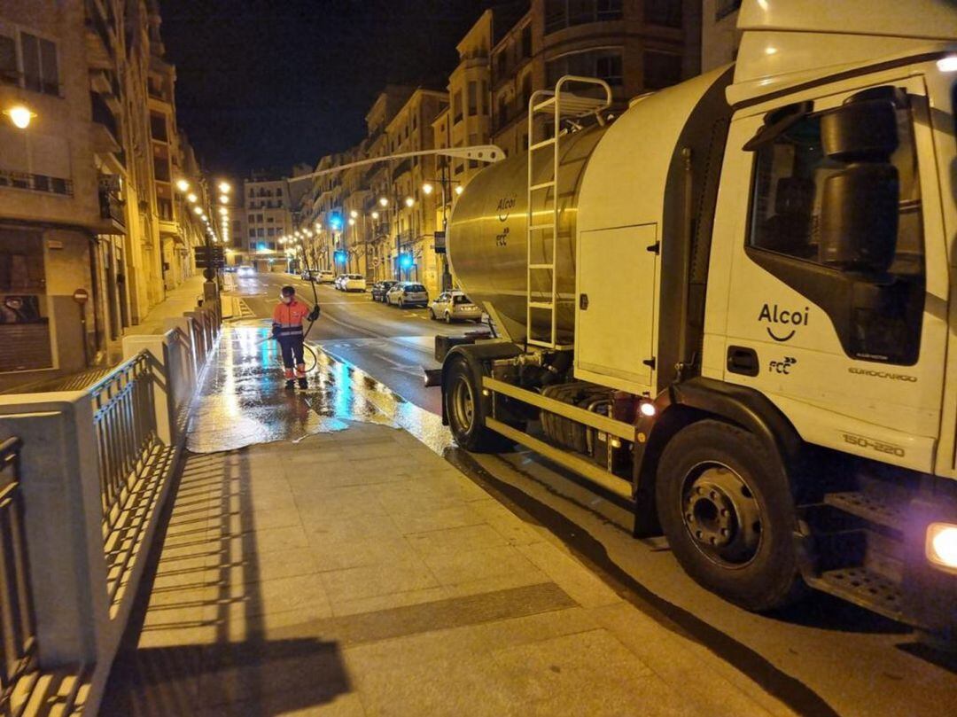 Un operario desinfectando la acera del puente de San Jorge de Alcoy.